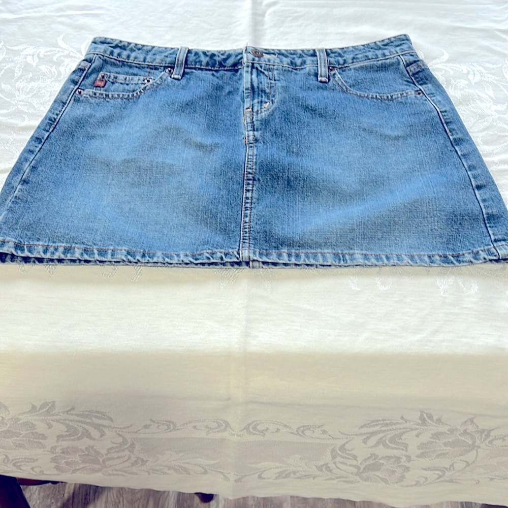 Lei young woman’s blue jean cotton mini skirt with front zipper, metal buttons